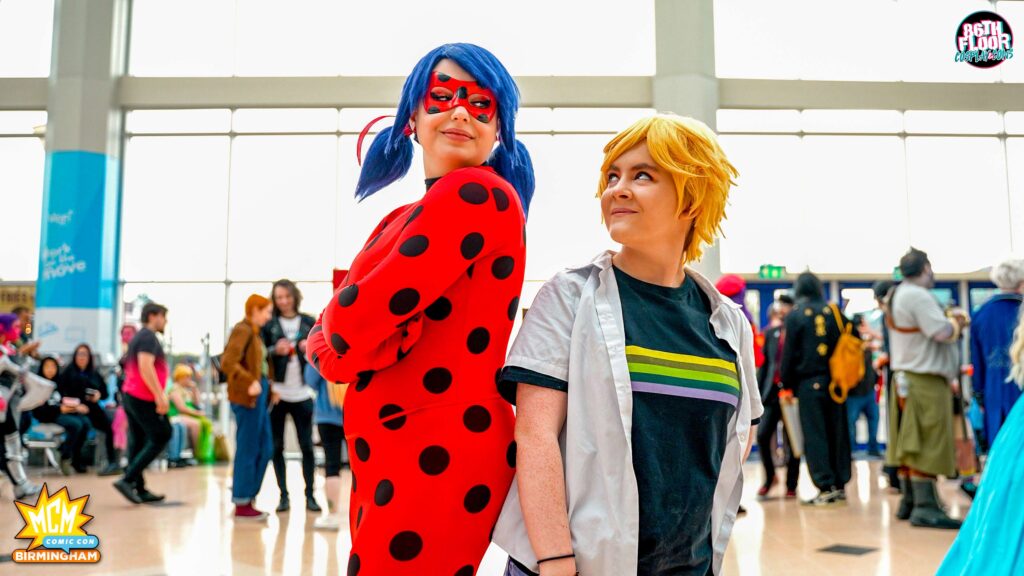 magicosplays & lottie.does.cosplay as Ladybug and Adrien Agreste from Miraculous Ladybug at MCM Birmingham Comic Con 2022